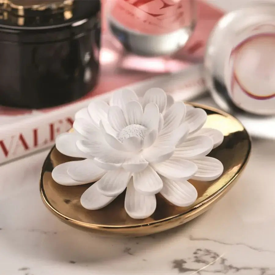 Signature porcelain flower diffuser in a gold dish, showcasing the exquisite design of our Diffusers collection.