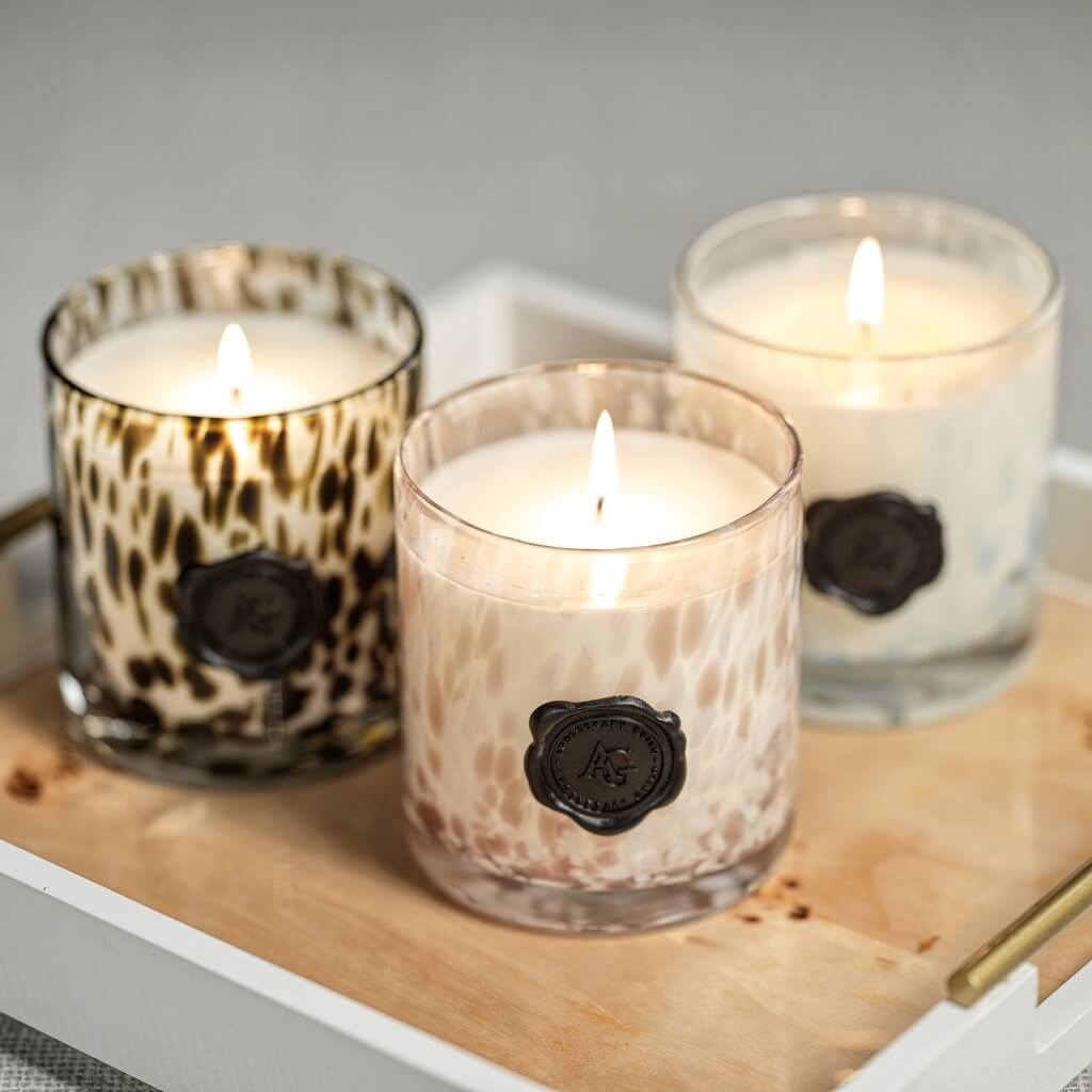 Elegant candles in decorative glass holders from the UNDER $100 collection, perfect for home decor.