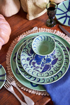 Amalfi Dessert Plate Green - 9.1" Diameter styled on a wooden table with other ceramic dishware and linens.