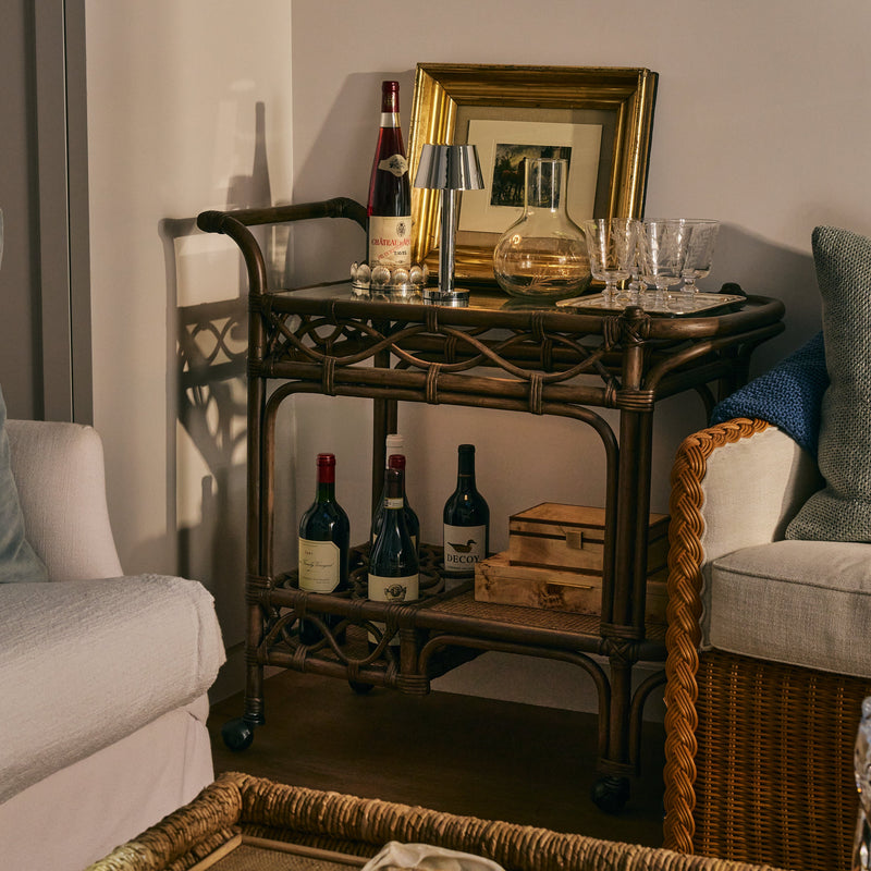 Bar cart with wine bottles and glasses in a living room setting
