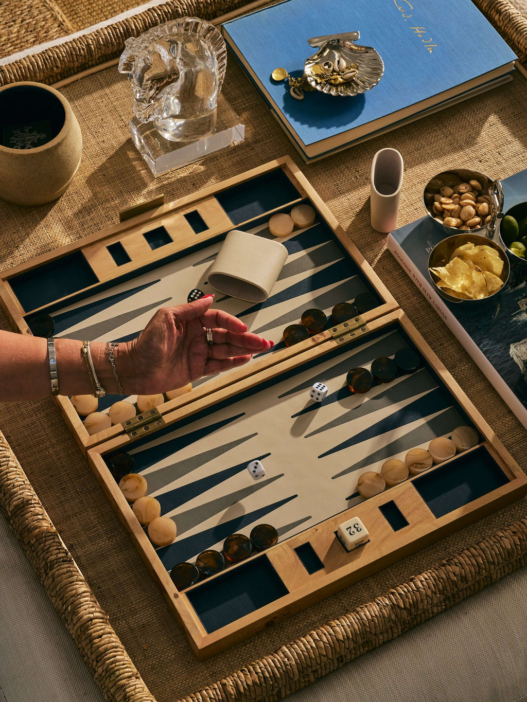 A beautiful Marbella Backgammon Set displayed on a textured table surface, showcasing elegant game pieces and dice.
