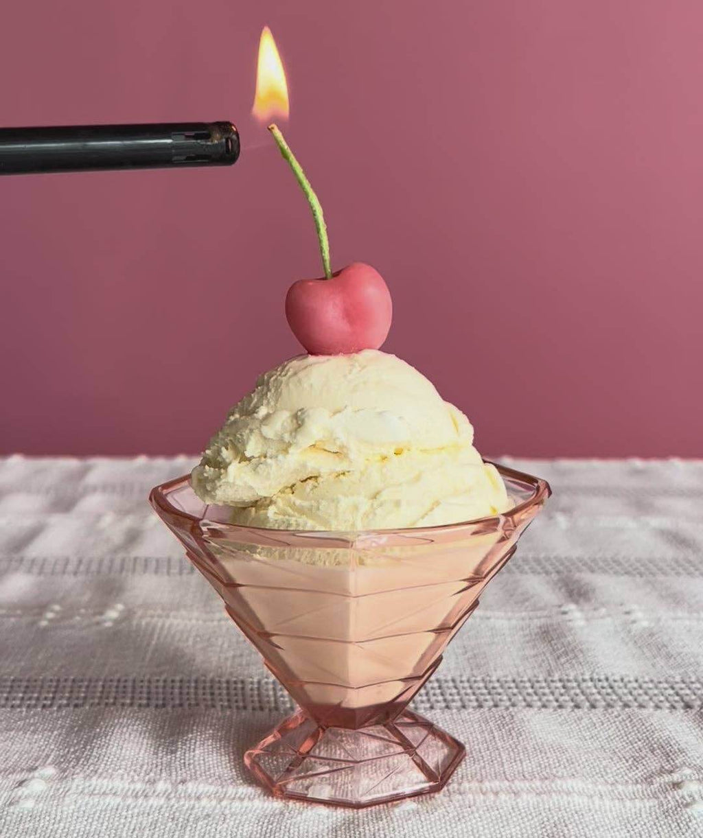 Pink Cherry Birthday Beeswax Candles on top of a dessert with a pink background and a flame