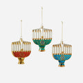 Three colorful Menorah ornaments hanging against a white background