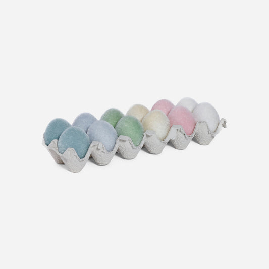Pastel-colored bath bombs in a cardboard holder on a white background