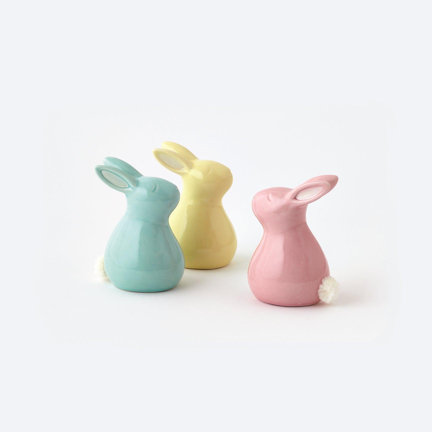 Three colorful ceramic rabbit-shaped items on a white background