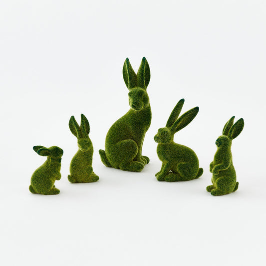 Set of green rabbit figurines on a white background