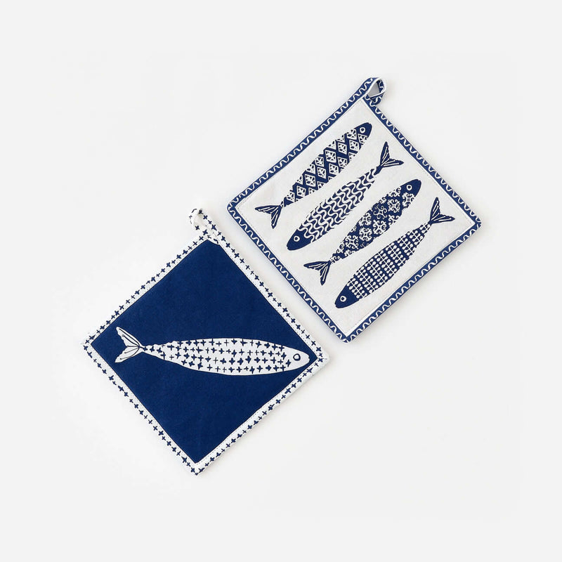 Set of two assorted fish-shaped quilted hot pads for kitchen and table use.