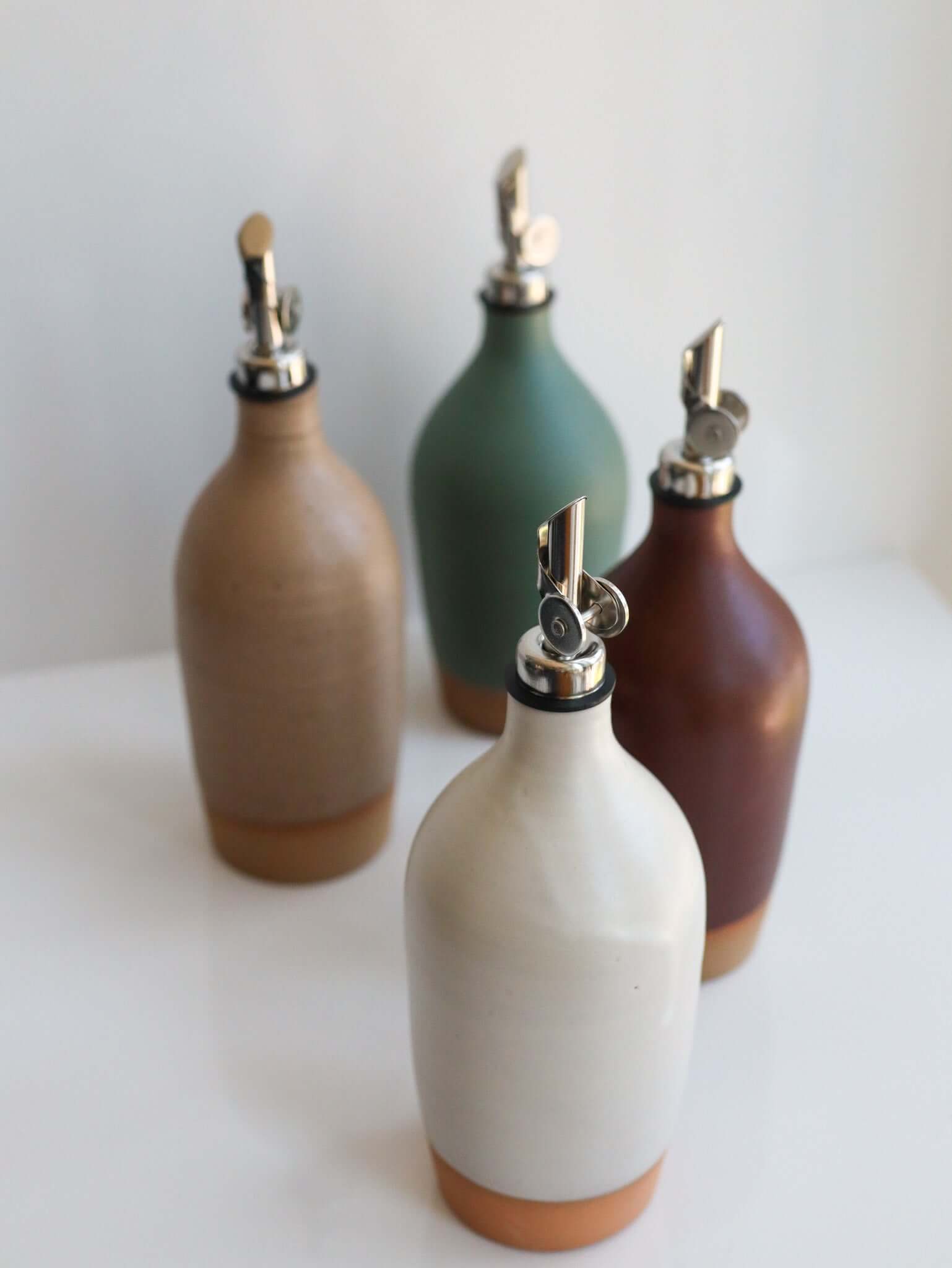 Tall Handmade Ceramic Oil Bottle set of four in different colors with polished pourers.