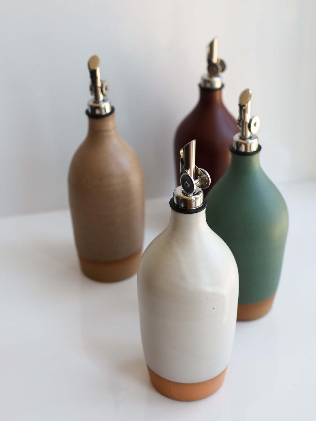 Tall Handmade Ceramic Oil Bottle collection in various matte glazes with polished pourers.
