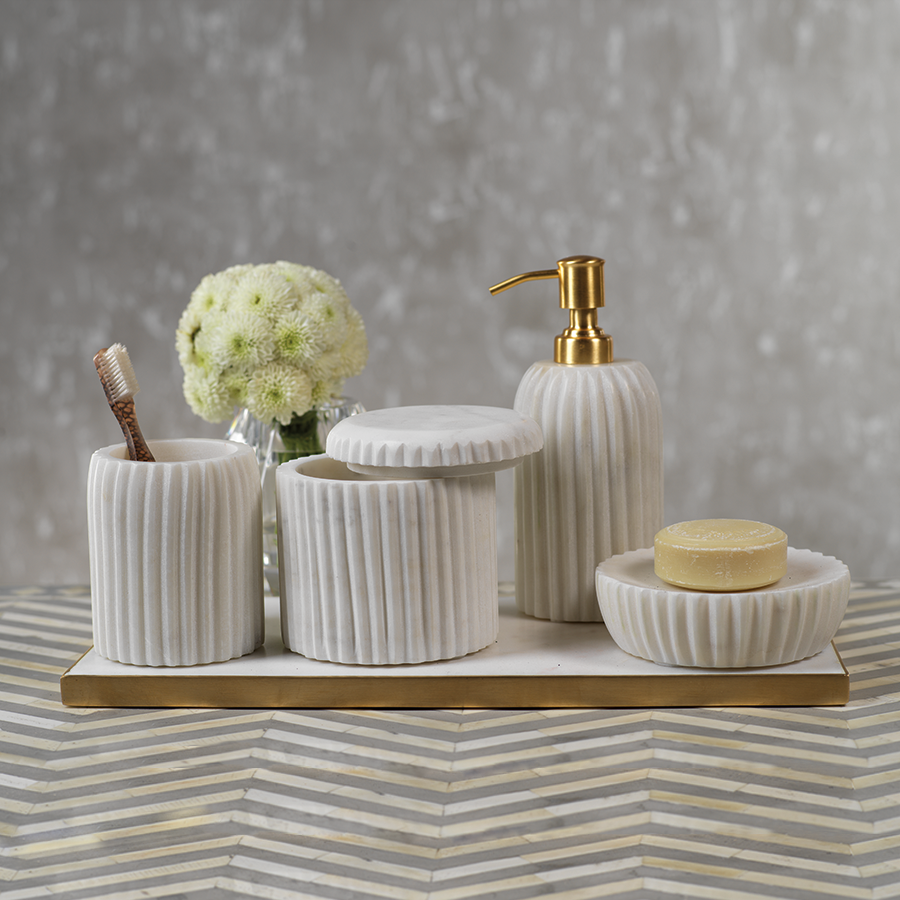Bathroom accessories including a toothbrush holder, containers, and a soap dispenser on a striped surface with a gray background.