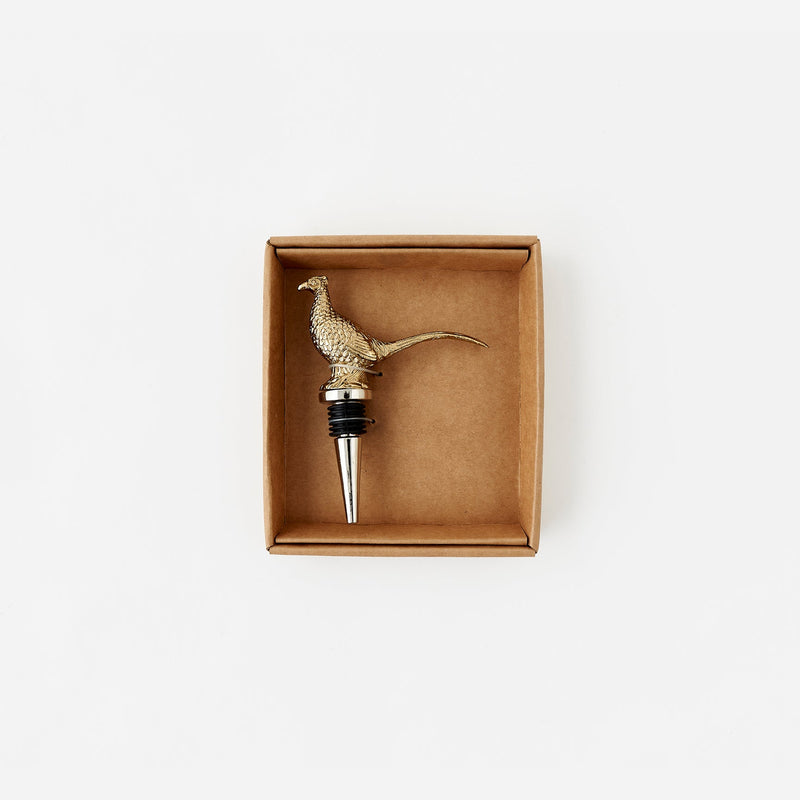 Brass pheasant-shaped bottle stopper in a cardboard box on a white background