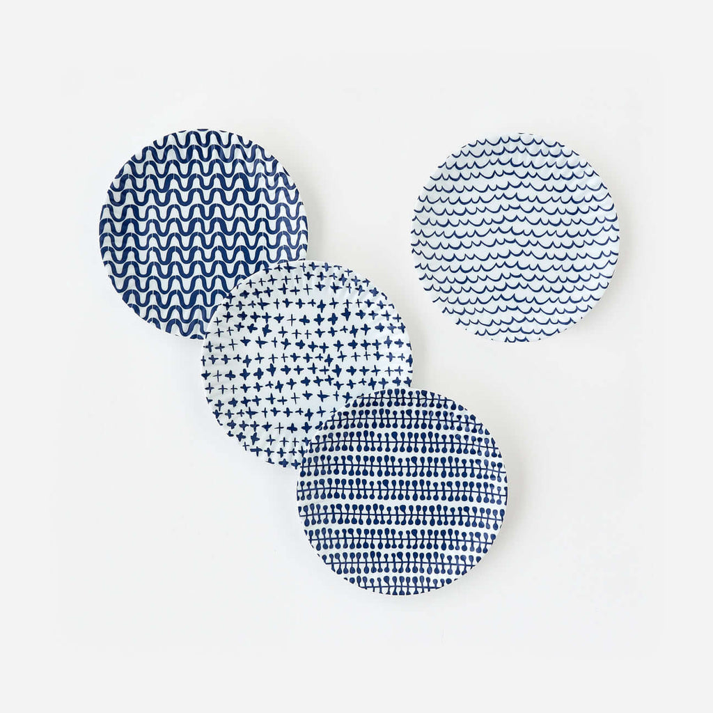 Set of four blue geometric melamine dinner plates inspired by classic paper plate designs.