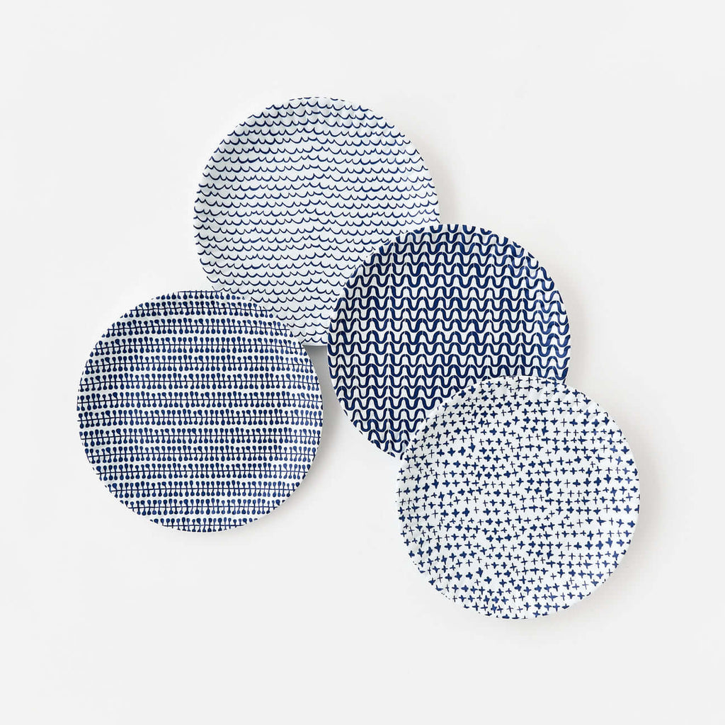Set of four blue geometric melamine dinner plates inspired by classic paper plate designs.