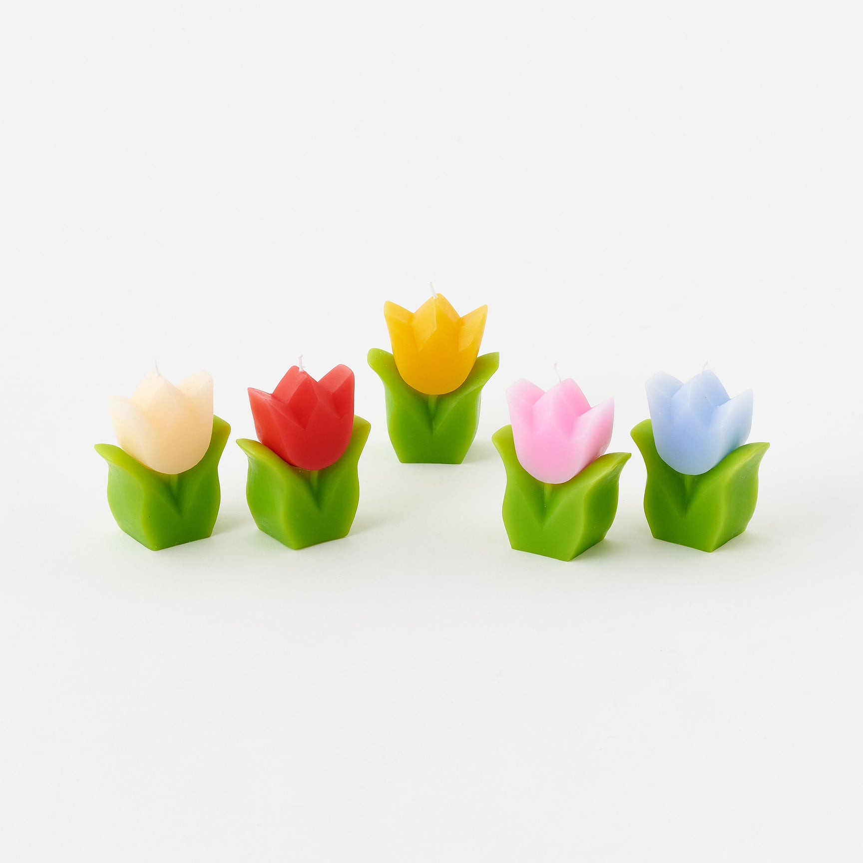 Set of colorful tulip-shaped candles on a white background
