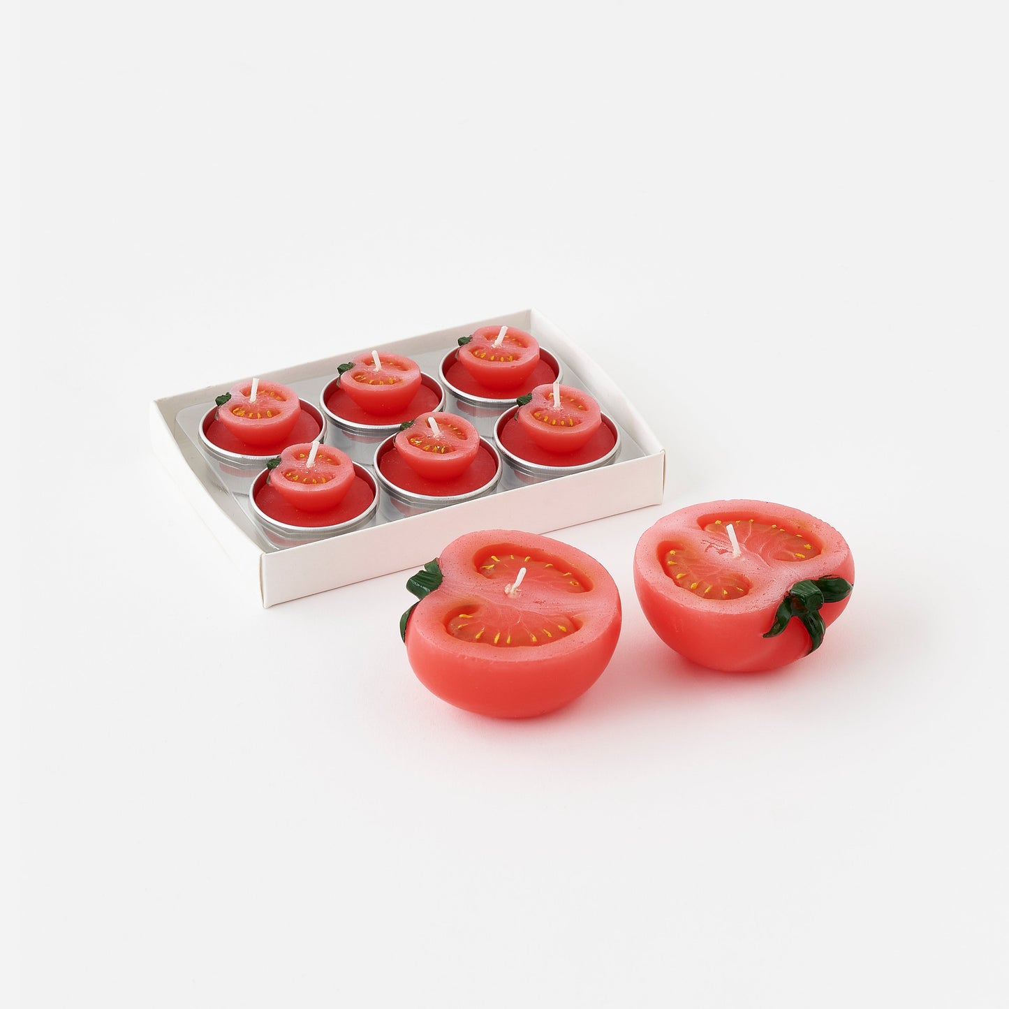 Tomato-shaped candles with a box of six on a white background
