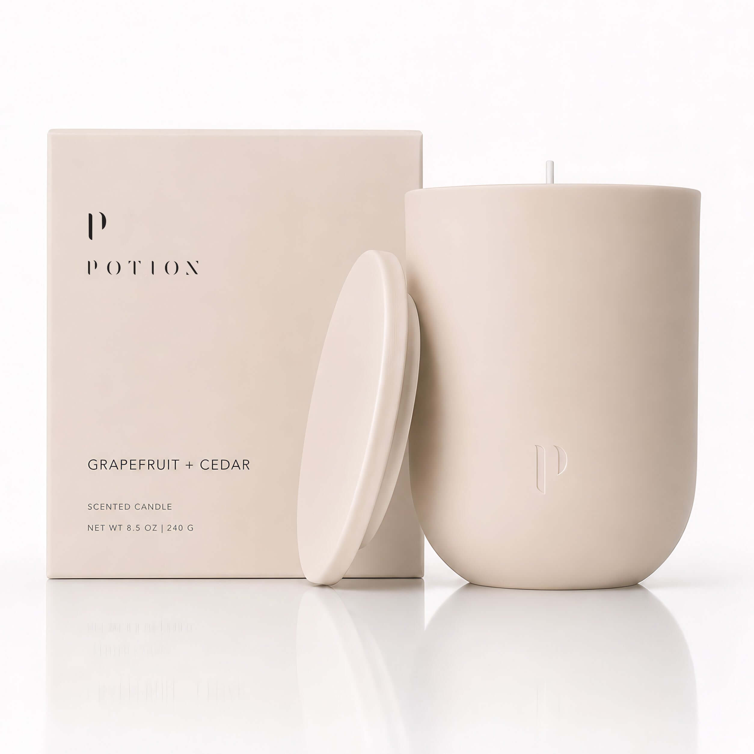 Grapefruit + Cedar Candle by POTION, featuring a natural design and elegant packaging.