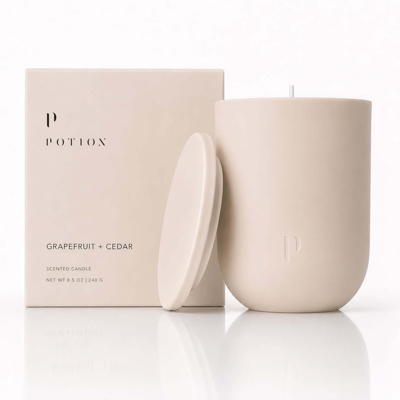 Grapefruit + Cedar Candle by POTION, featuring a natural design and elegant packaging.