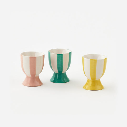 Three colorful ceramic egg cups on a white background