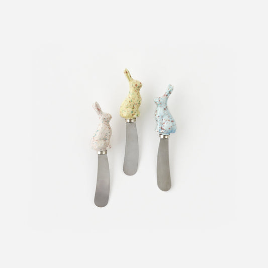 Three decorative butter knives with rabbit handles on a white background