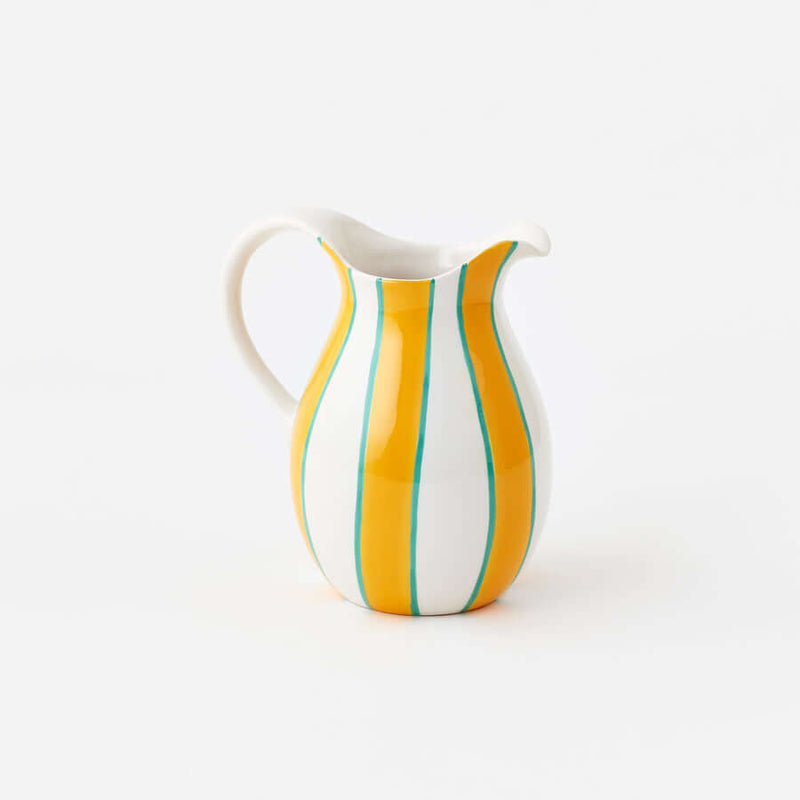 Terrazzo Striped Pitcher with bold yellow stripes and teal accents, perfect for serving drinks.