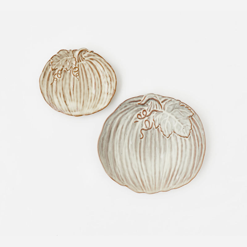 Two decorative ceramic pumpkins in cream and beige tones with brown outlines, displayed on a clean white background.