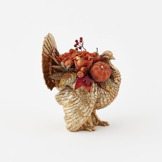 Decorative turkey figurine with autumnal elements on a white background