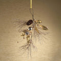 Decorative ornament with gold leaves, pinecones, and beads on a beige background