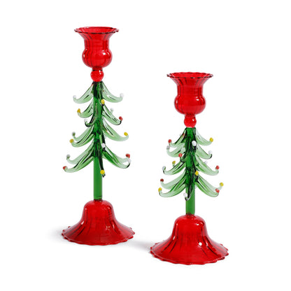 Two glass candle holders shaped like Christmas trees with red bases and red candle holders on a white background.