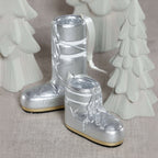 Après Ski Boots, Set of 6 Assorted silver holiday ornaments on a festive display.