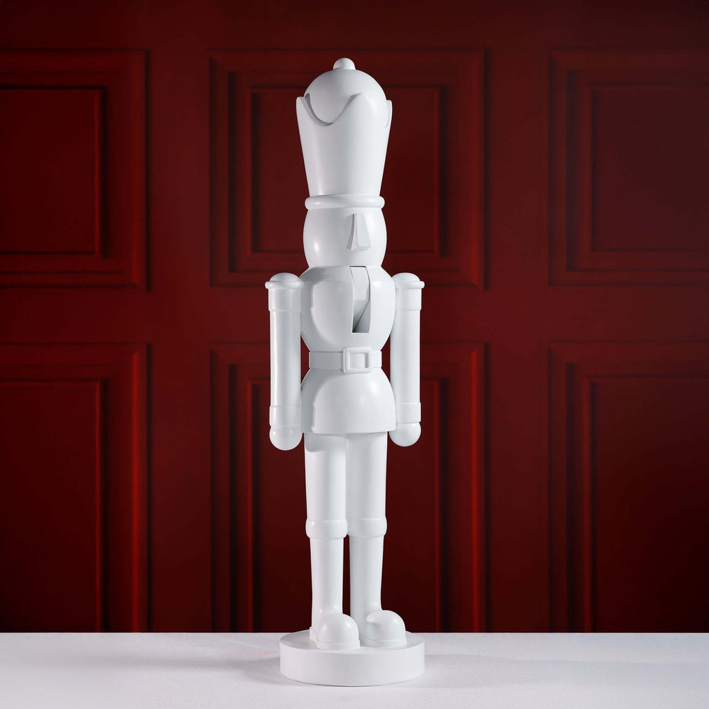 White nutcracker figurine against a red paneled wall