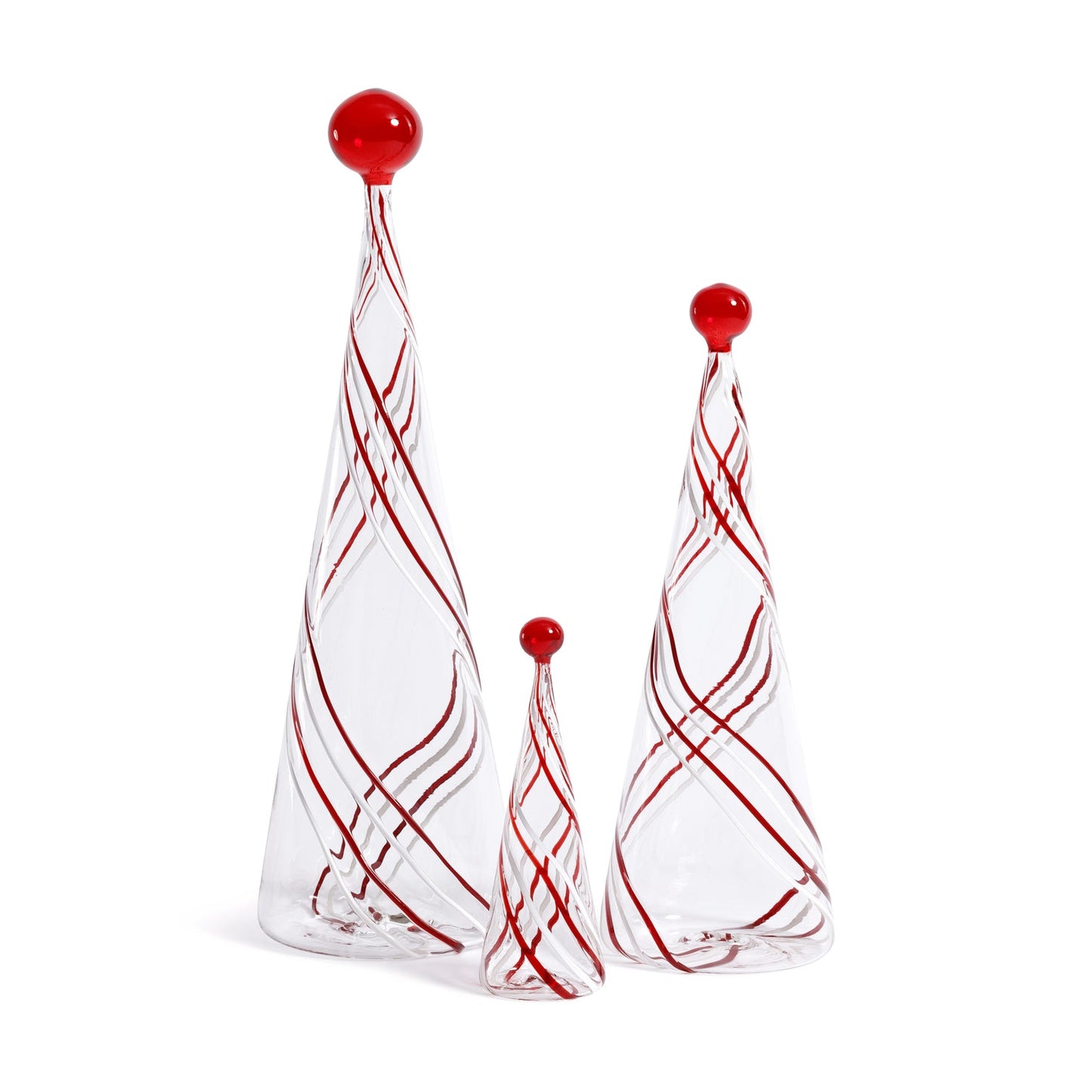 Set of three glass Christmas trees with red swirls and balls on a white background