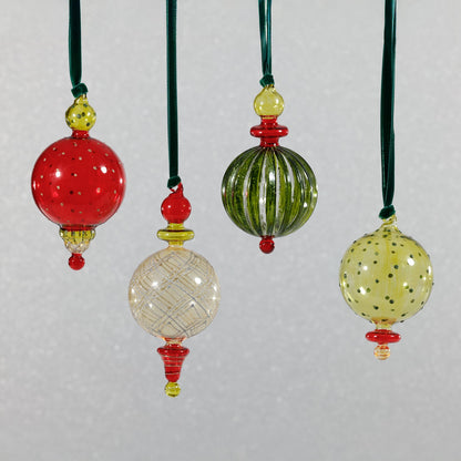 Set of colorful glass ornaments with green, red, and yellow accents on a light gray background.