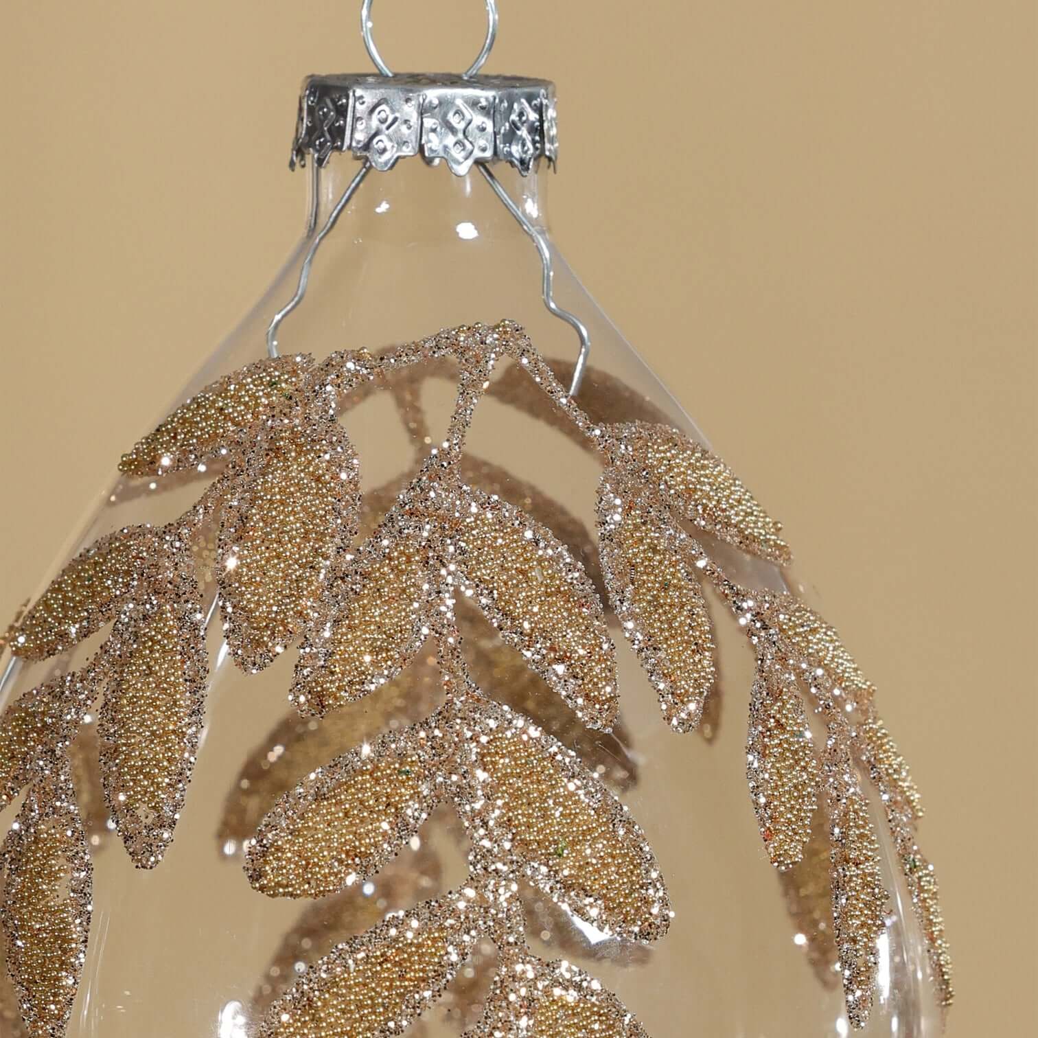 Decorative hanging ornament with gold leaf pattern on a beige background