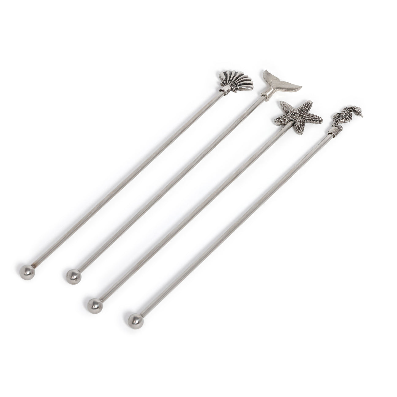 Set of four white swizzle sticks with starfish and shell designs on a white background