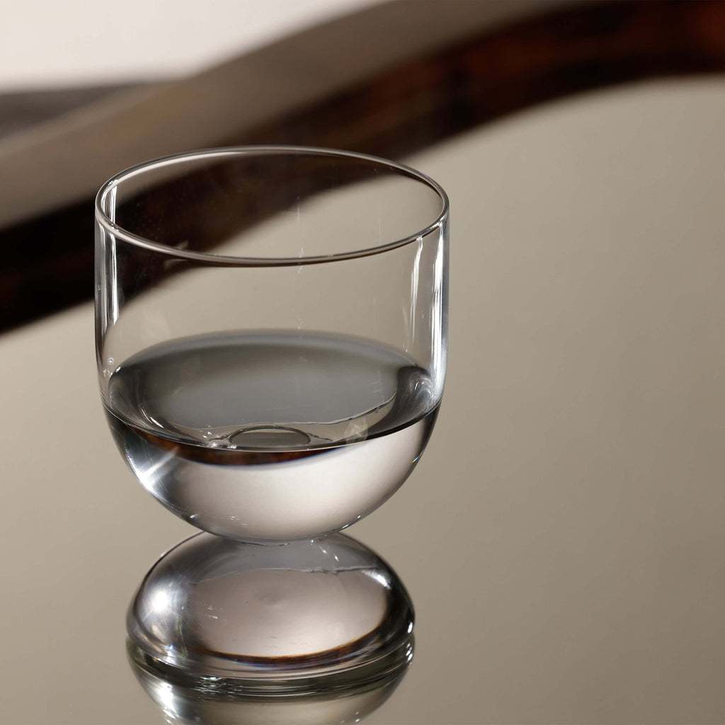 Elegant glass from the Madrid Glassware Collection reflecting light on a mirrored surface.