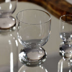Madrid Glassware Collection clear glass on a sculptural sphere base reflecting a stylish drinkware design.