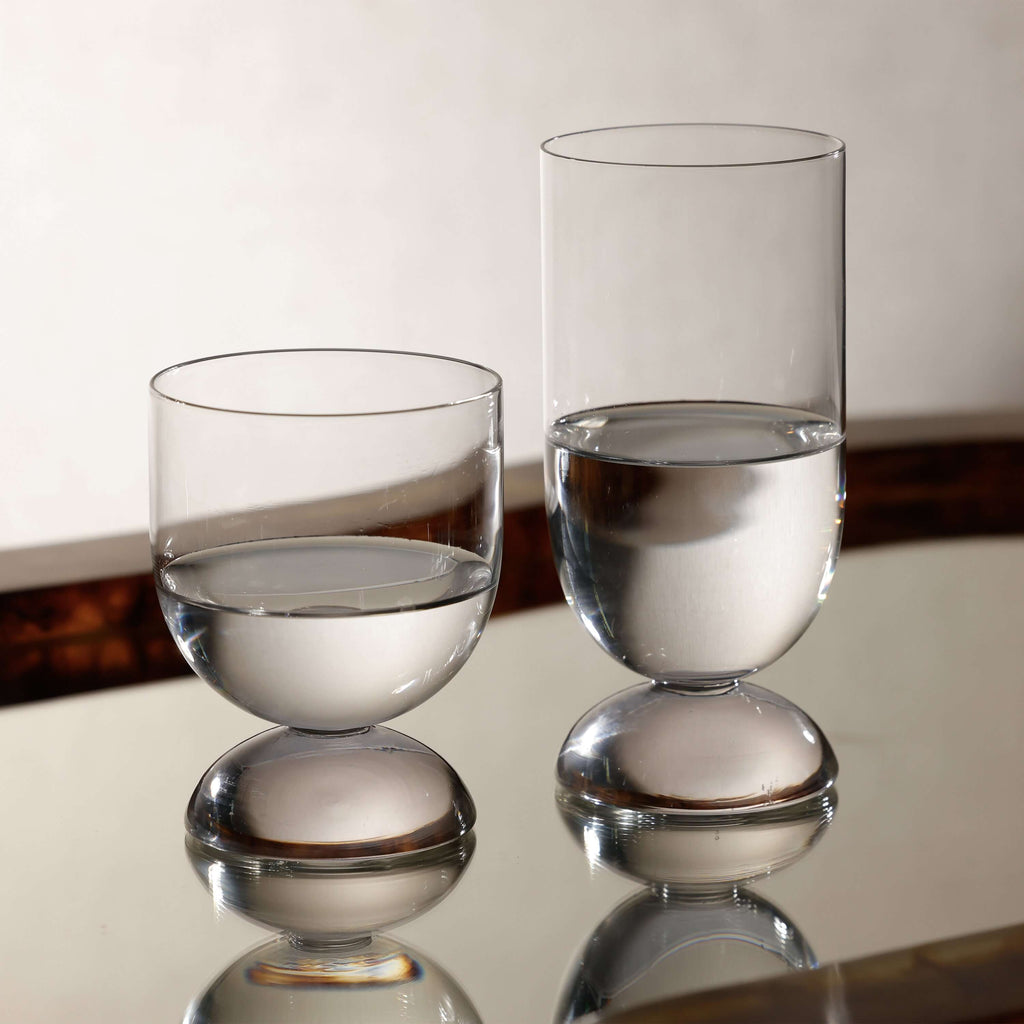 Madrid Glassware Collection featuring sculptural glasses with a solid sphere base on a reflective surface.