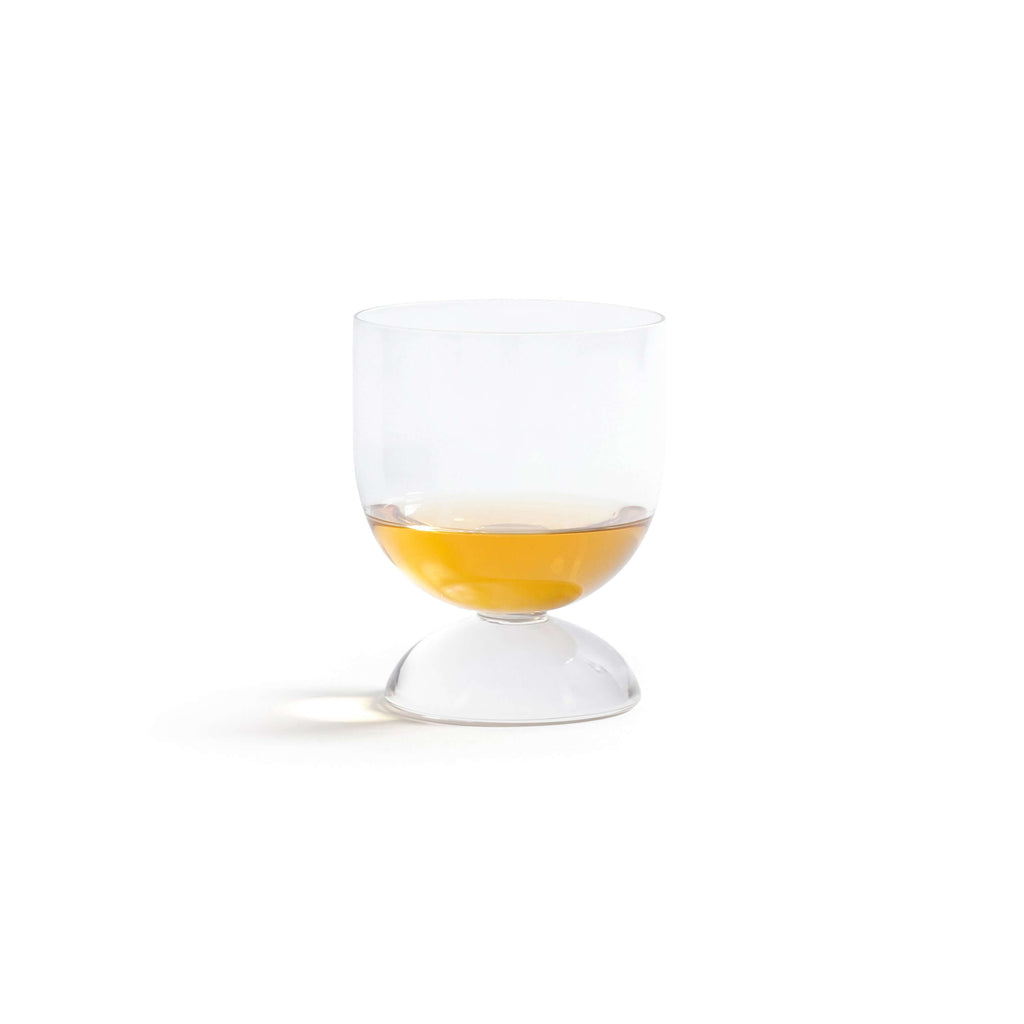 Madrid Glassware Collection: elegant glass with a solid sphere base, showcasing a drink in a sculptural design.