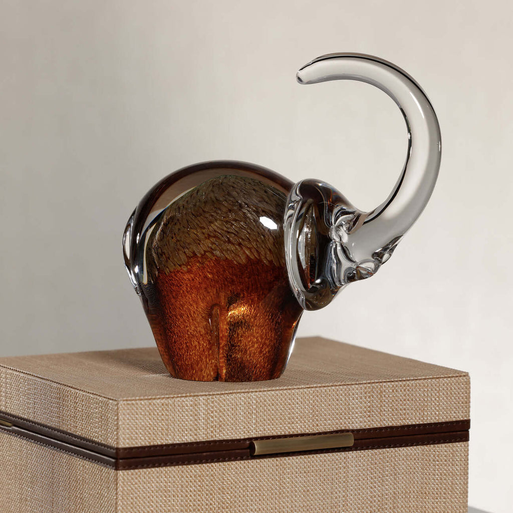 Great Elephant - Golden Amber Glass sculpture on a decorative box, crafted in rich amber glass with clear accents.
