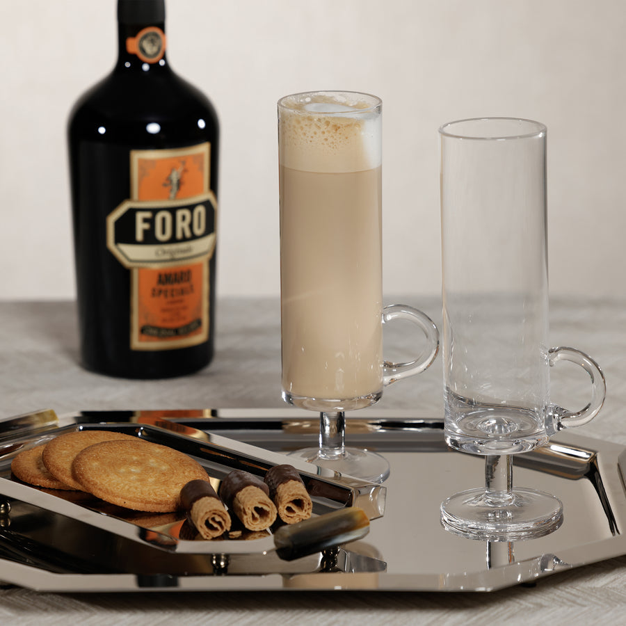 Tray with a bottle of Foro Amaro, two glasses, and cookies on a neutral background