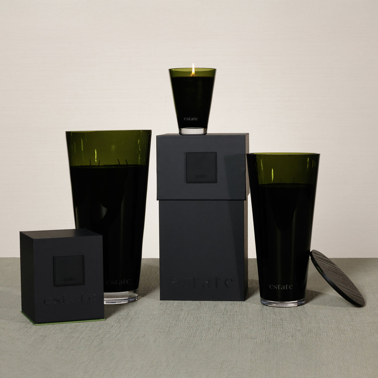 Set of black and green glass containers on a gray surface with a neutral background