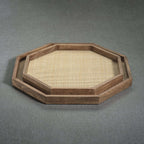 The Marais Tray features an octagonal mango wood design with woven rattan inlay, showcasing artisanal craftsmanship.