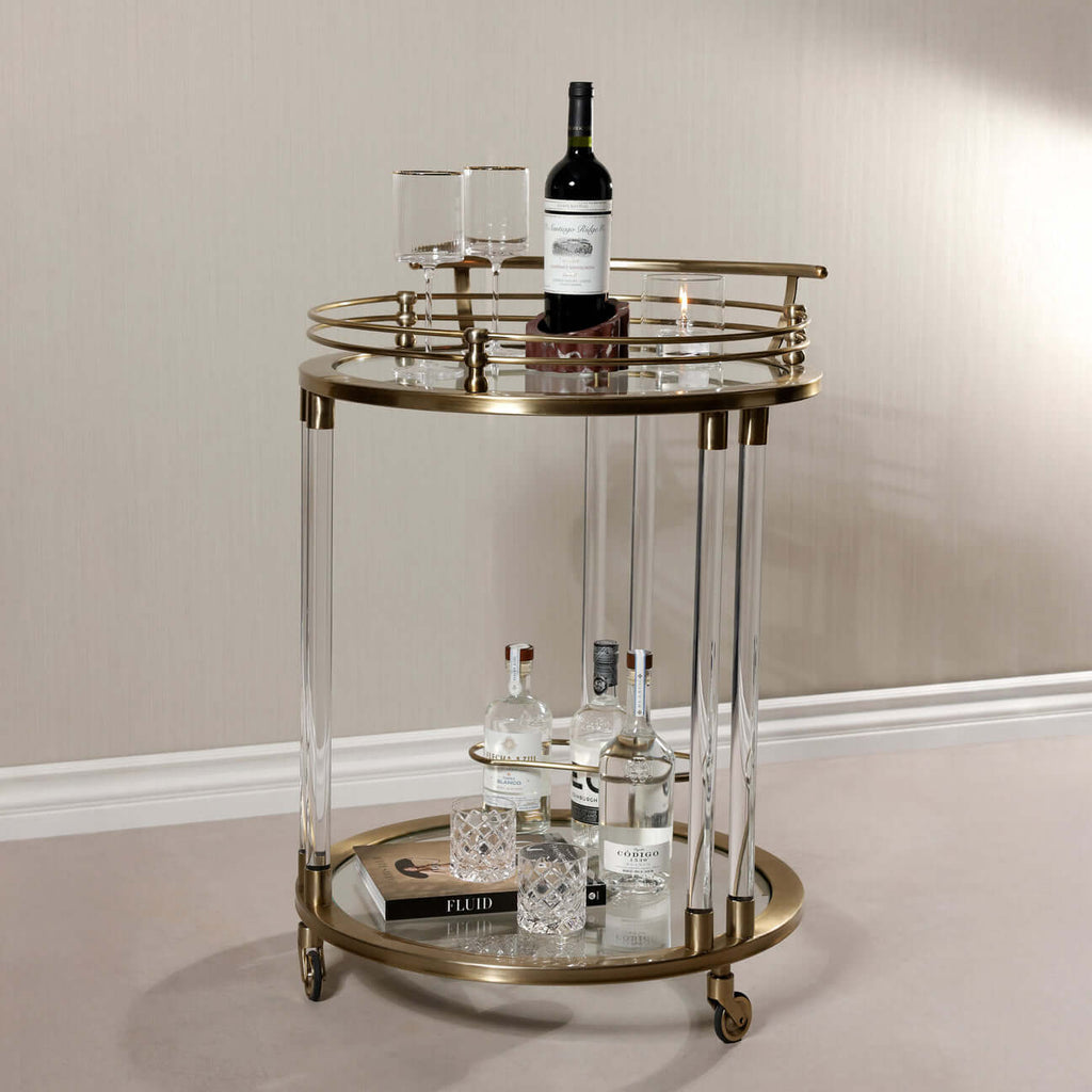 Opus Round Bar Cart / Trolley with mirrored top, brass accents, and acrylic legs, ideal for stylish home décor.