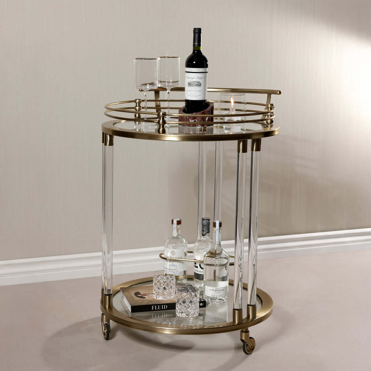Opus Round Bar Cart / Trolley with mirrored top, brass accents, and acrylic legs, ideal for stylish home décor.