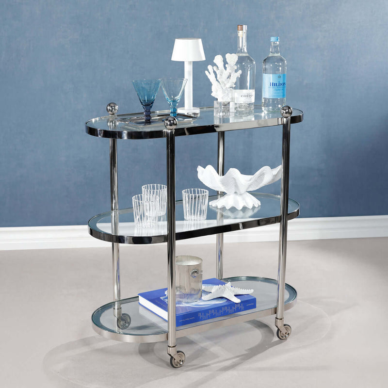 Oval Round Bar Cart / Trolley with clear glass tiers and silver frame, styled with glasses and decor.