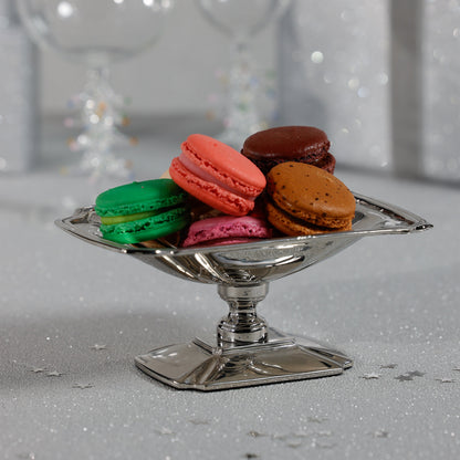 Colorful macarons on a silver dish with a blurred background