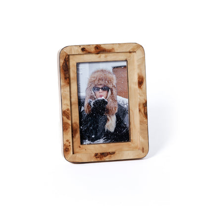 Wooden photo frame with a picture of a person wearing winter clothing on a white background