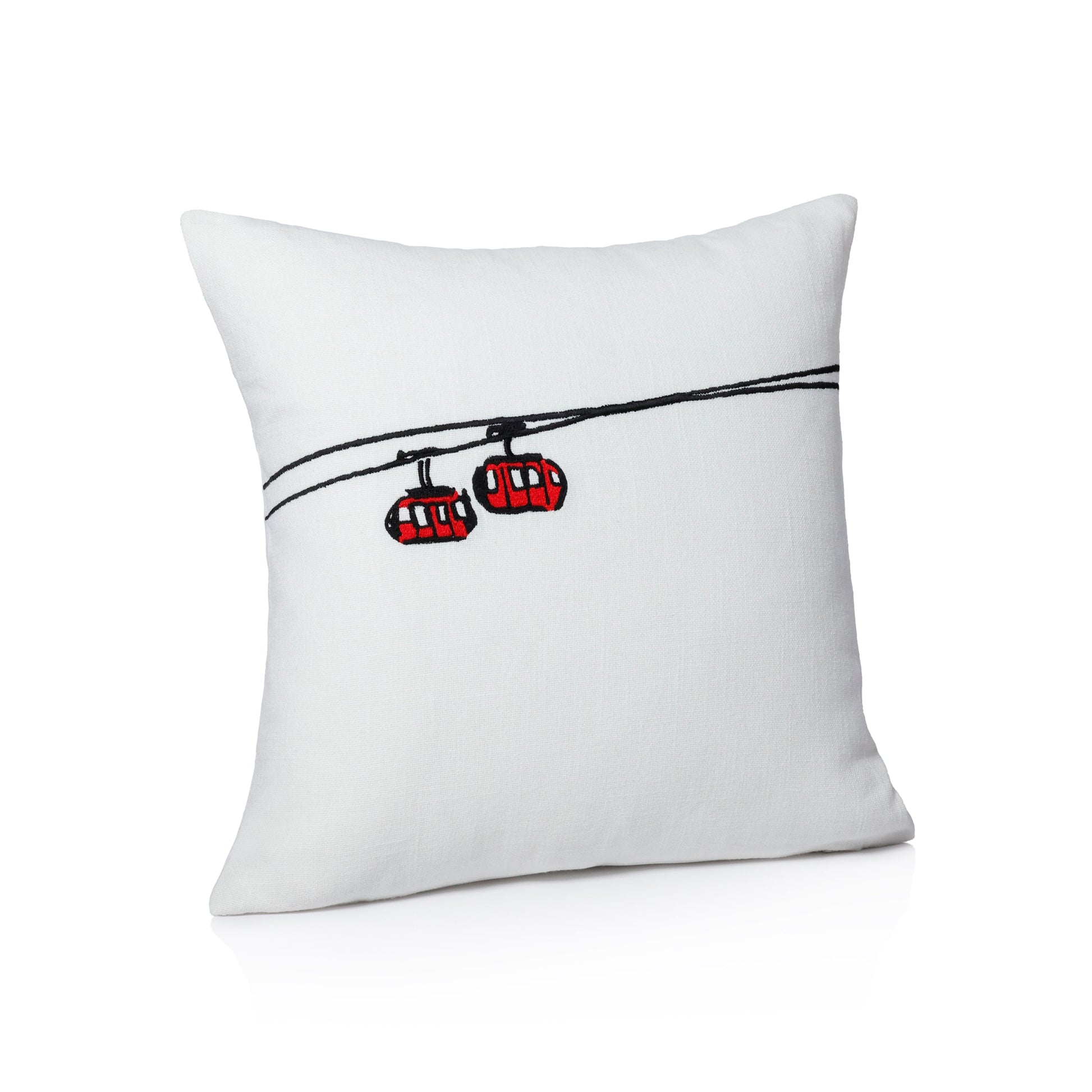 White pillow with red and black cable car design on a white background