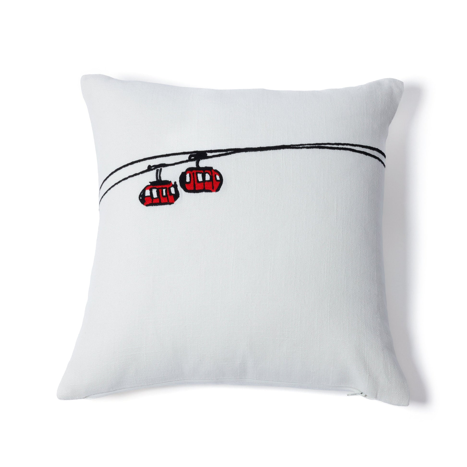White pillow with red cable cars design on a white background