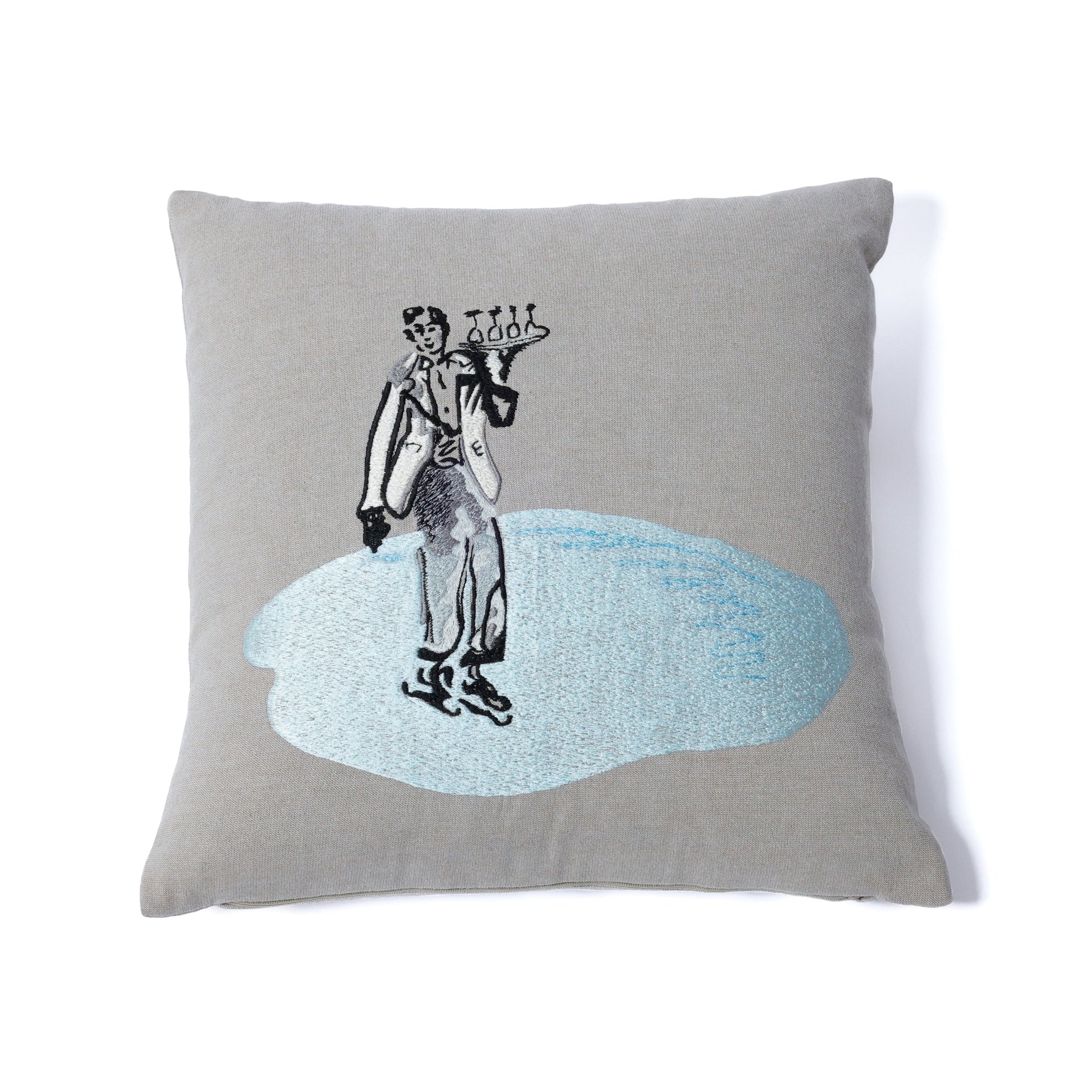 Gray pillow with a black and white illustration of a person on a skateboard on a blue splash background